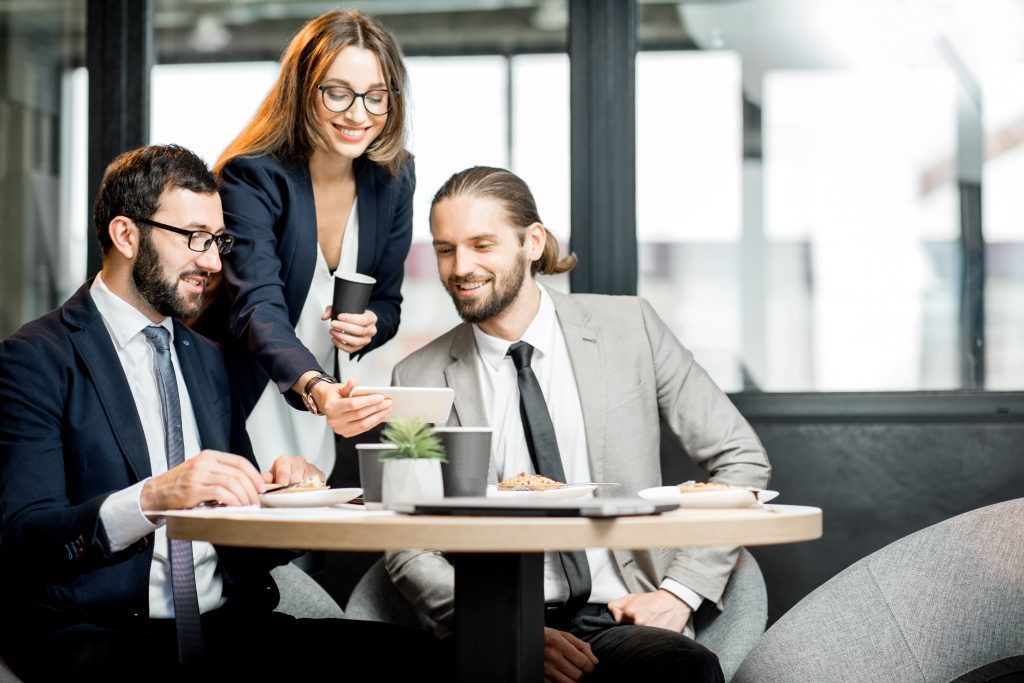 Business people having fun sitting together during the coffee break in the modern cafe intreior